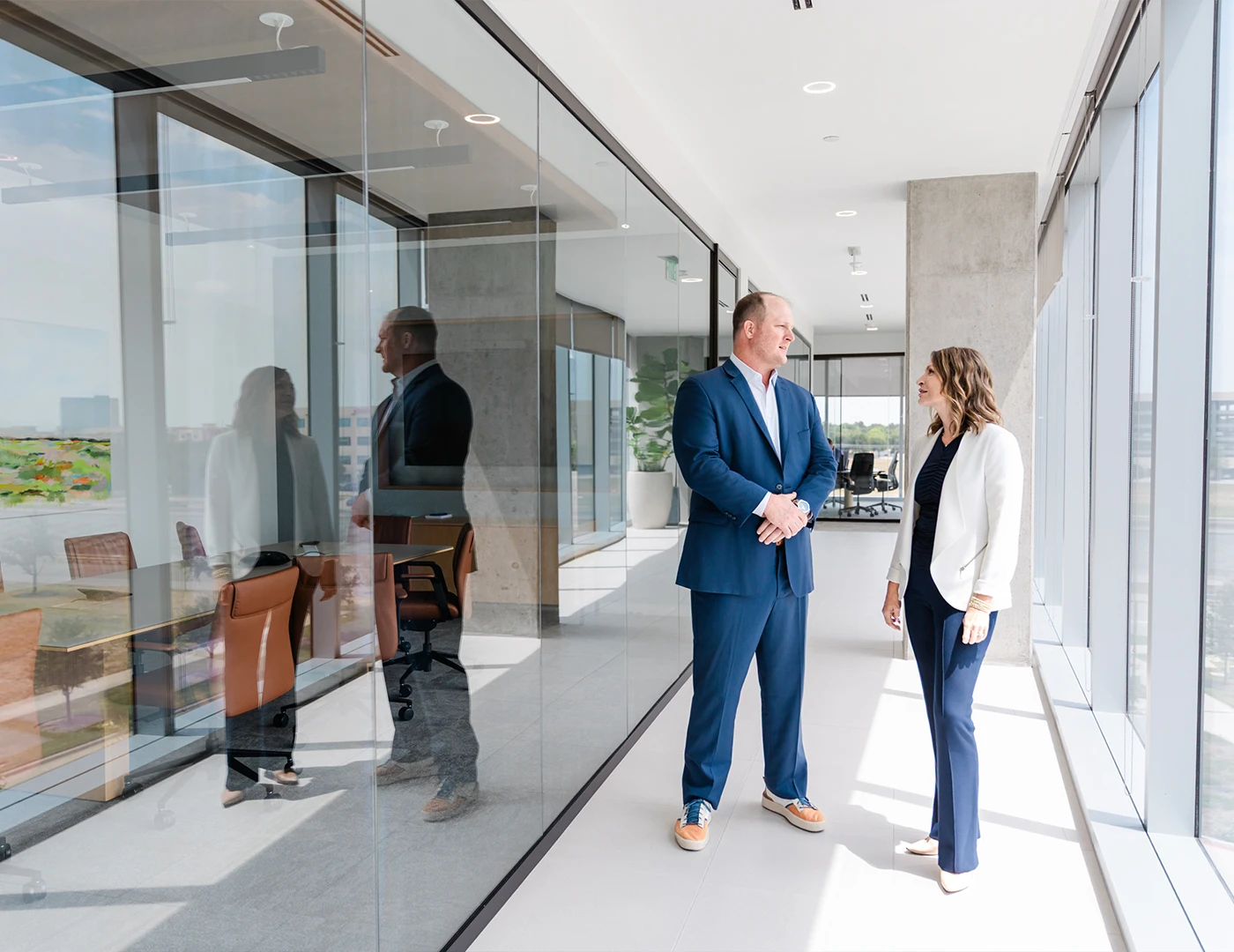 7 Pillars Advisory advisors talking in a bright office hallway