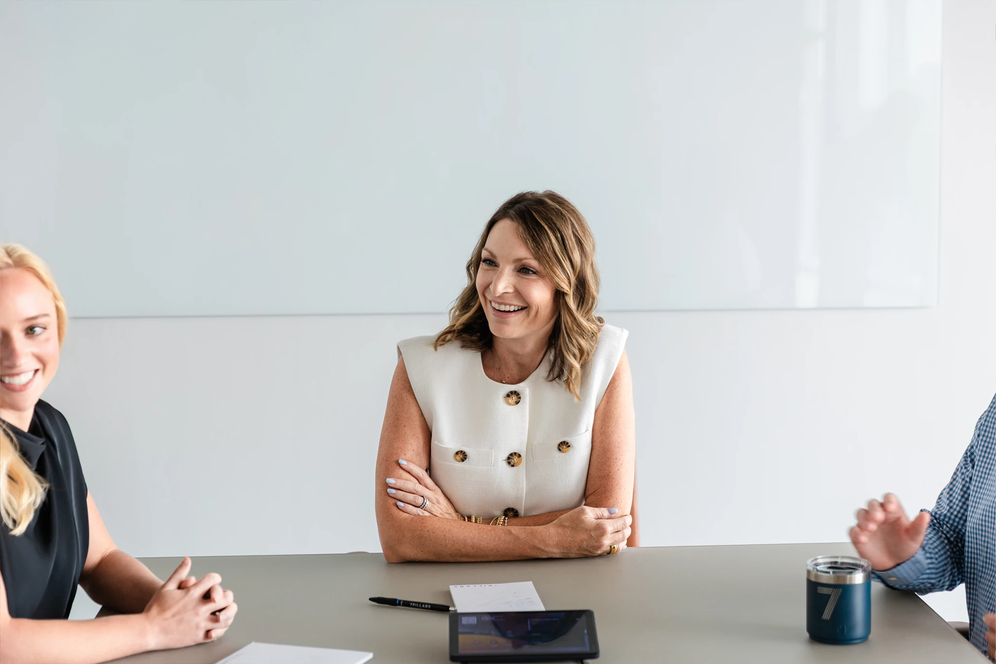 Smiling advisor seated at a conference table during a client meeting